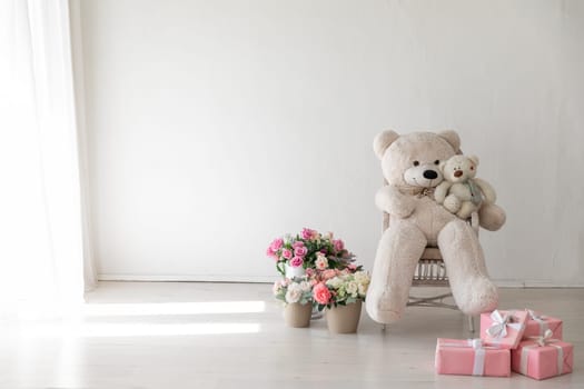 a large stuffed toy and a small one in a chair with flowers in the room