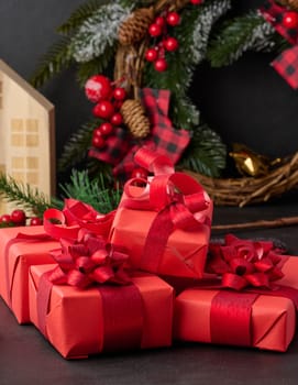 Gift boxes wrapped in red paper against Christmas decor background