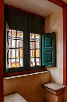 Old window inside a historic baroque church with a view of the colonial houses in the city of Ouro Pretro, Minas Gerais