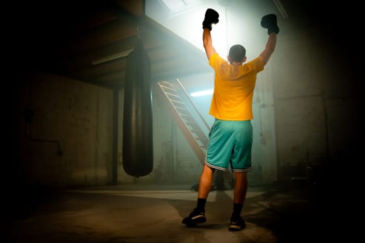 Boxer celebrating win on dark background. Horizontal copy space sport background. High quality photo