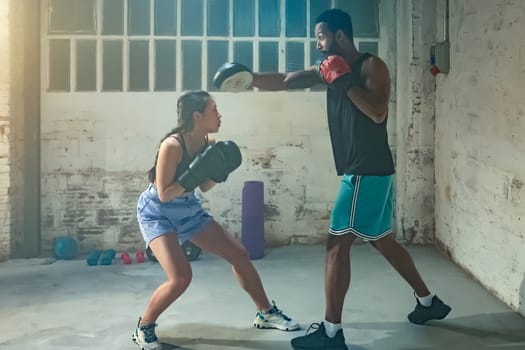 Pretty young woman trains in boxing sparring with male. High quality photo