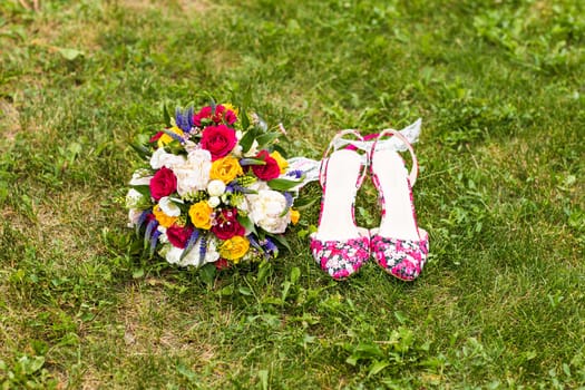 wedding bouquet and bridal shoes on the grass