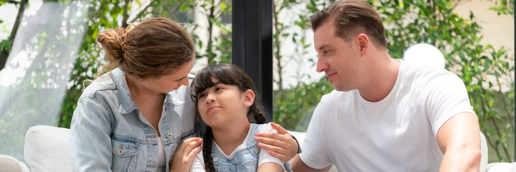 Parents comforting their daughter with loving hug, helping her feel secure and protected from fear, rest her head on shoulder. Happy family love and child care support concept. Panorama Synchronos