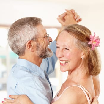 Senior couple, dancing and happy in home, romantic and ballroom for fun, touch and love. Retirement, bonding together and smile for husband, wife and quality time with tango, retired and elderly.