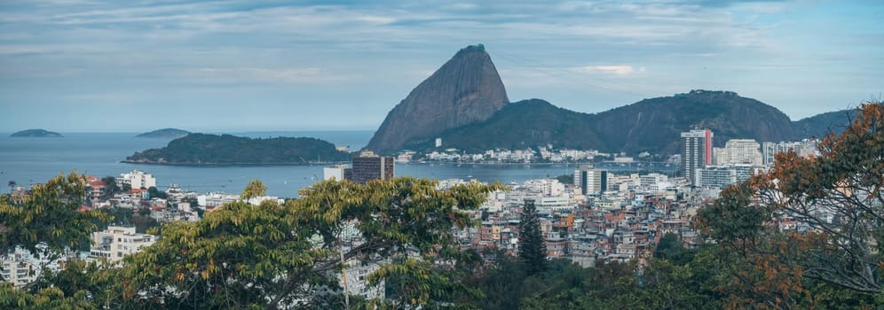 Stunning view of Botafogo Bay in Rio, featuring modern apartments, Sugarloaf Mountain and a cable car.