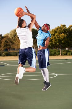 Basketball, training and men jump on court in game with ball, workout and outdoor exercise in sports. Fitness, competition and athlete shooting for a goal, challenge or stretching to score in match.
