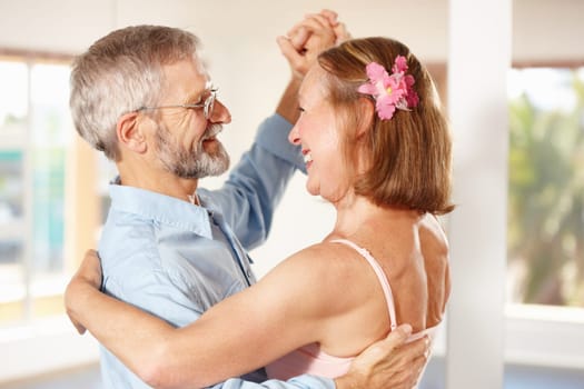 Senior couple, dancing and happy in house, love and ballroom for fun, touch and romantic. Retirement, bonding together and smile for husband, wife and flower with tango, retired or elderly people.
