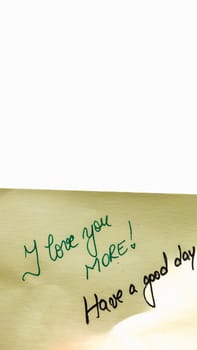 I love you more handwriting text close up isolated on yellow paper with copy space.