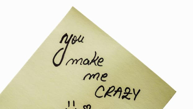 You make me crazy handwriting text close up isolated on yellow paper with copy space.