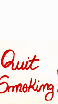 Quit smoking handwriting text close up isolated on yellow paper with copy space.