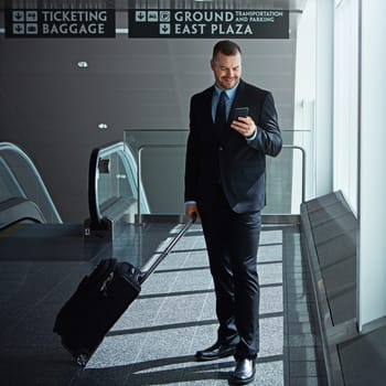 Travel, airport or happy business man with phone, luggage or suitcase on social media or waiting. Booking, airplane or corporate worker texting on mobile app on international flight transportation.