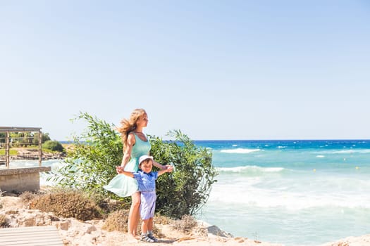 Portrait of happy mother and son at sea, outdoor.