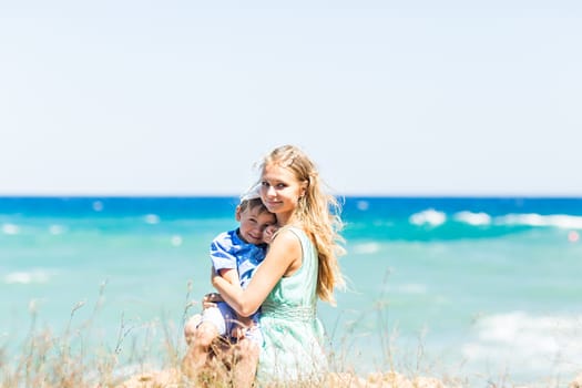 Portrait of happy mother and son at sea, outdoor.