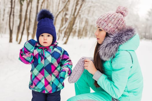 Little girl and her mom having fun on a winter day.