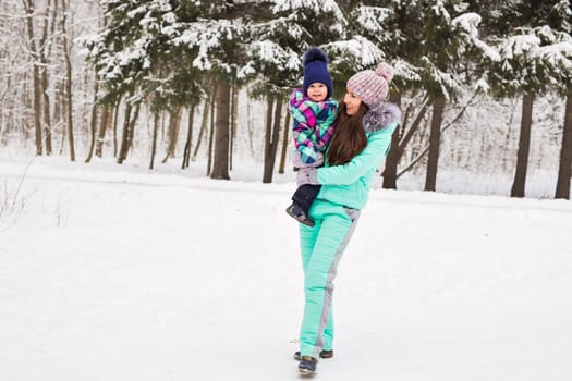 Little girl and her mom having fun on a winter day.