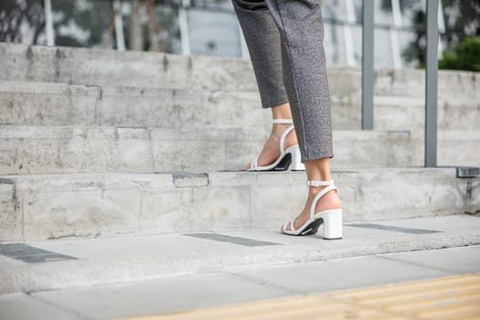 During the morning rush to the office businesswoman legs in motion are focused on climbing the stairs. This closeup captures the essence of progress, ambition, and the dedication of a modern manager.