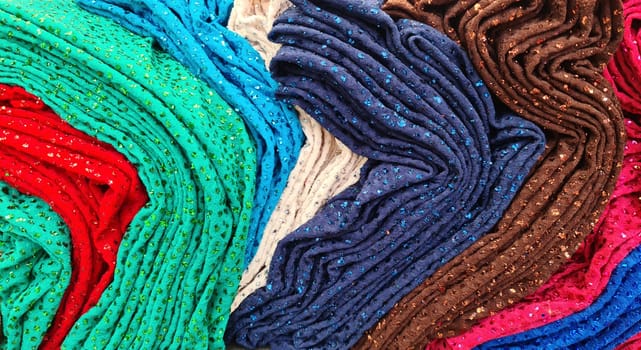 Samples of cloth and fabrics in different colors found at a fabrics market.