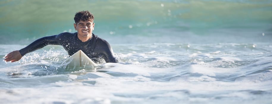 Surfing, man and swimming in sea ocean of summer adventure, nature freedom or mockup banner. Happy young surfer guy, board and waves in water, beach and relax for holiday, sunshine travel or wellness.