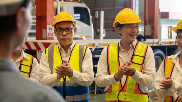 Happiness and joyful atmosphere, smiling factory worker and engineer celebrate with factory executive or manager after achieve factory output and surpassing the maximum quota. Exemplifying