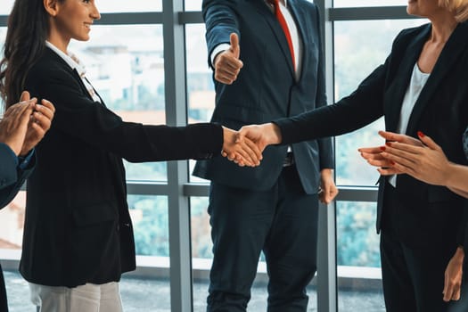 Business people handshake in corporate office showing professional agreement on a financial deal contract. Jivy