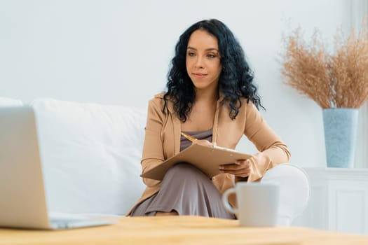 African-American woman using laptop computer for crucial work on internet. Secretary or online content writing working at home.