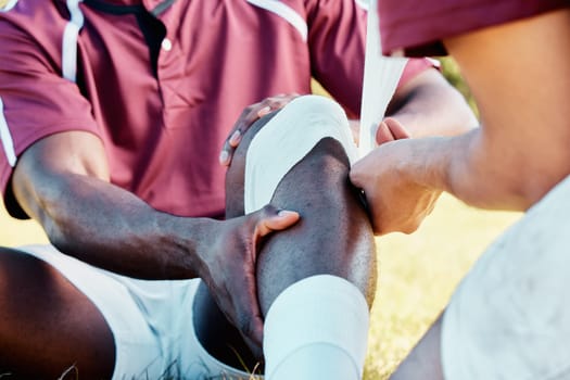 Knee pain, sport injury and bandage on athlete outdoor, rugby and fitness with black man, team and first aid. Medical emergency, wound and sports accident, training and exercise with help and medic.