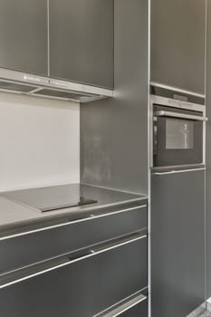 a modern kitchen with grey cabinets and stainless steel appliances on the counter top is white marble flooring in this photo