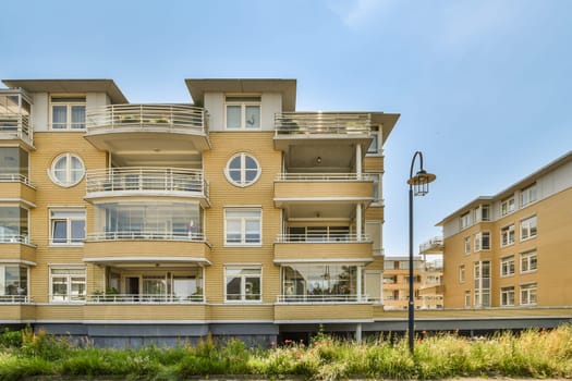 an apartment building with balks on the balconys and balks on the second floor in the photo is clear blue sky