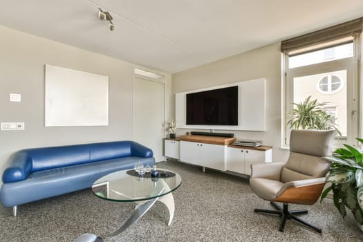 a living room with a couch, chair and flat screen tv on the wall in the room is very clean