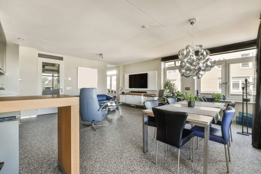 a kitchen and dining area in a modern home with white walls, grey flooring and large windows looking out onto the street