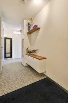 a hallway with some shelves on the wall and flowers in vases sitting on top of cabinetd cupboards