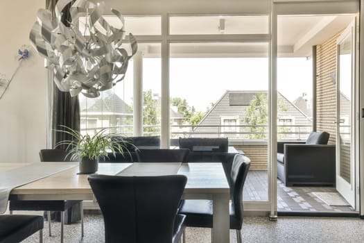 a dining room with chairs and a table in front of the glass door that leads to an outside patio area