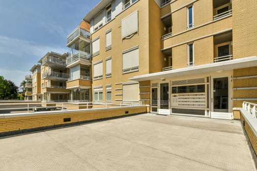 an outside area with some buildings in the background and a white fence on the other side of the building there is a blue sky