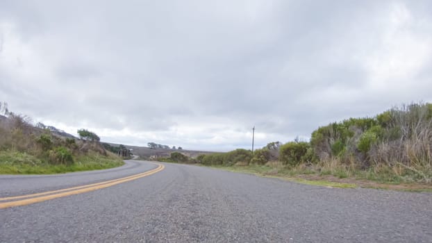 In this serene winter scene, a vehicle carefully makes its way along Los Osos Valley Road and Pecho Valley Road within Montana de Oro State Park.