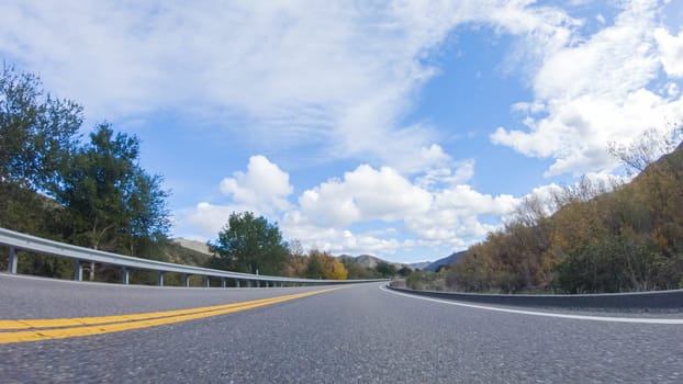 Vehicle is cruising along the Cuyama Highway under the bright sun. The surrounding landscape is illuminated by the radiant sunshine, creating a picturesque and inviting scene as the car travels through this captivating area.