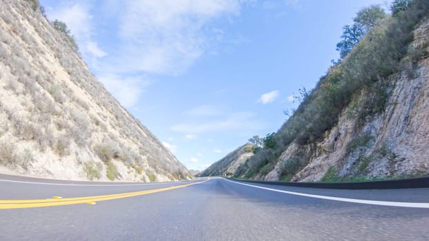 Vehicle is cruising along the Cuyama Highway under the bright sun. The surrounding landscape is illuminated by the radiant sunshine, creating a picturesque and inviting scene as the car travels through this captivating area.