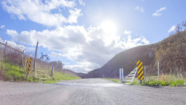 Vehicle is cruising along the Cuyama Highway under the bright sun. The surrounding landscape is illuminated by the radiant sunshine, creating a picturesque and inviting scene as the car travels through this captivating area.