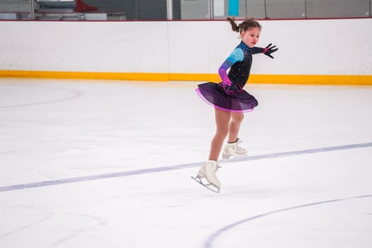 Little girl practicing before her figure skating competition at the indoor ice rink.