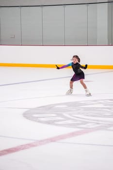 Little girl practicing before her figure skating competition at the indoor ice rink.