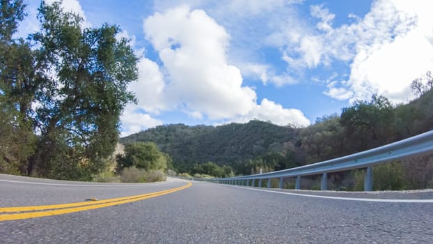 Vehicle is cruising along the Cuyama Highway under the bright sun. The surrounding landscape is illuminated by the radiant sunshine, creating a picturesque and inviting scene as the car travels through this captivating area.