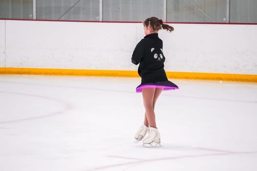 Little girl practicing before her figure skating competition at the indoor ice rink.