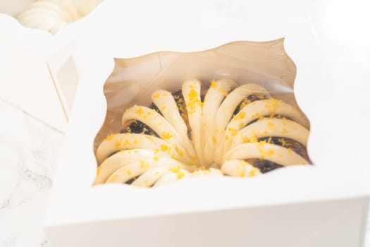 The freshly baked bundt cakes are carefully nestled into white paper boxes, preparing them for secure transportation while maintaining their delectable appearance.