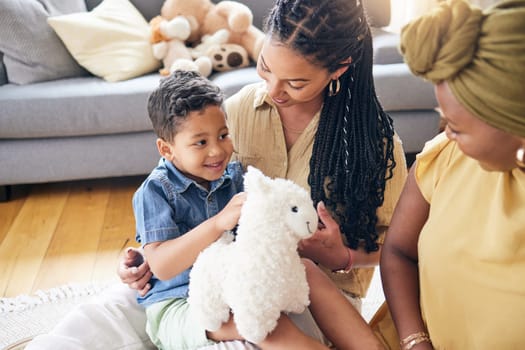 Happy lesbian couple, child and adoption in home for family bonding or quality time on living room floor. LGBTQ or gay women and little boy in happiness together for holiday weekend or break in house.