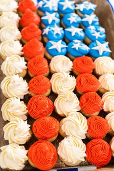 Arranging mini vanilla cupcakes in the shape of the American flag.