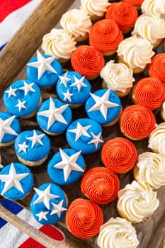 Arranging mini vanilla cupcakes in the shape of the American flag.
