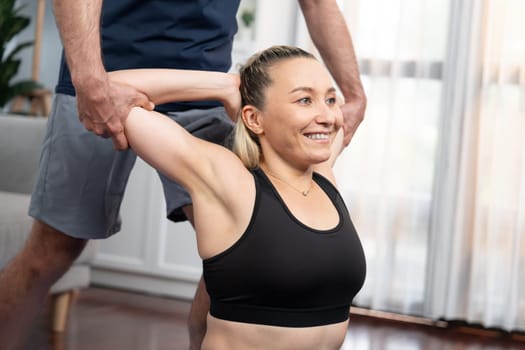 Happy active senior couple in sportswear being supportive and assist on yoga posture together at home. Healthy senior man and woman lifestyle with yoga exercise. Clout