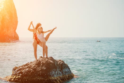 Silhouette mother and daughter doing yoga at beach. Woman on yoga mat in beach meditation, mental health training or mind wellness by ocean, sea