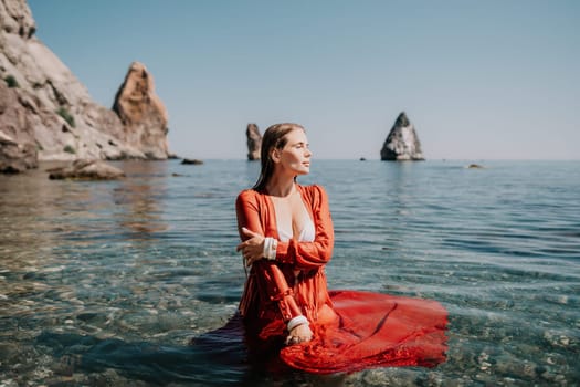 Woman travel sea. Happy tourist taking picture outdoors for memories. Woman traveler looks at the edge of the cliff on the sea bay of mountains, sharing travel adventure journey.