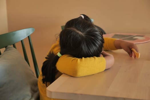 a upset child girl cover her face with hand .