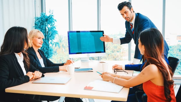 Business people in the conference room with green screen chroma key TV or computer on the office table. Diverse group of businessman and businesswoman in meeting on video conference call . Jivy